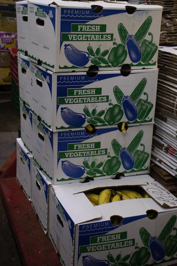 Cajas apiladas de verduras frescas y plátano