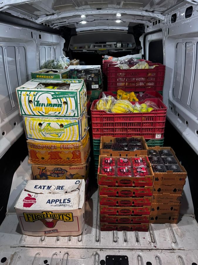 Interior de la camioneta de Kilsafran cargada con cajas de plátano, frutos rojos y huacales de verdura