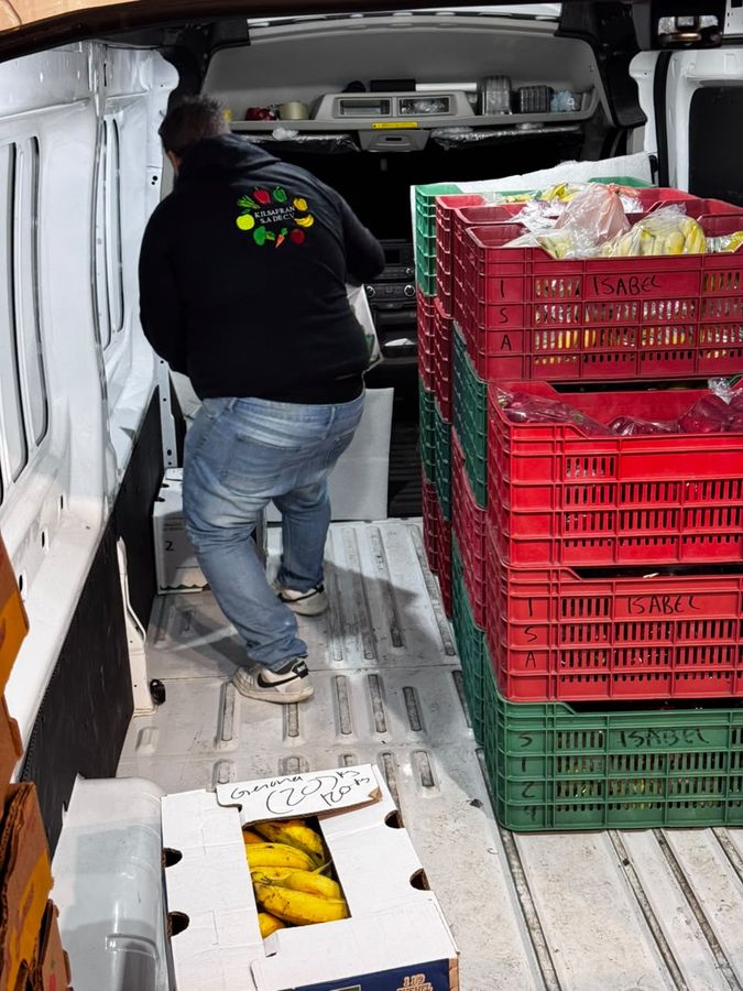 Integrante del equipo de Kilsafran acomodando huacales y cajas dentro de la camioneta