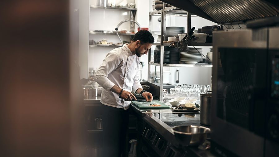 Cocinero preparando ingredientes en una cocina profesional